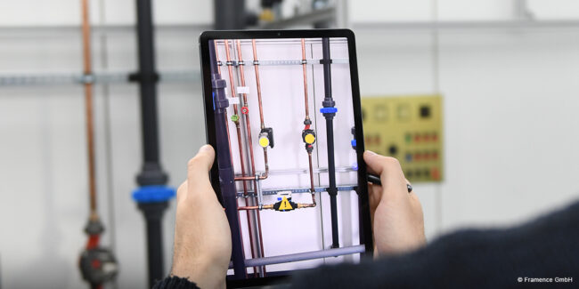 Framence_Blog_Augmented_Reality Person holding a tablet that uses augmented reality to display information about a pipe system in a technical facility.