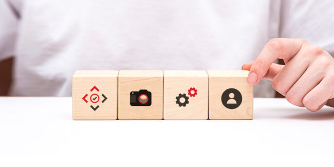 Framence_Blog_Service Hand pushes wooden blocks with symbols for Framence, camera, settings and user.