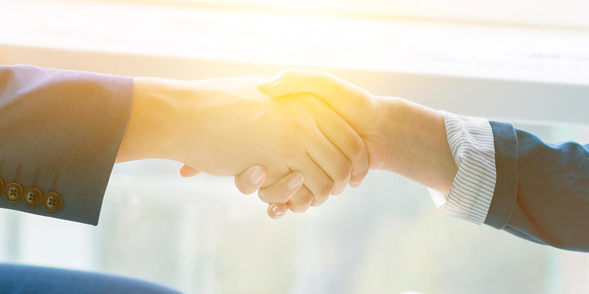 Framence_Blog_Partner Image with a symbolic handshake between two people, slightly faded with dark border and light reflection in the center