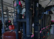 Interior view of a technical facility with black pipelines, pressure gauges, red safety labels, and various valves in a maintenance room.